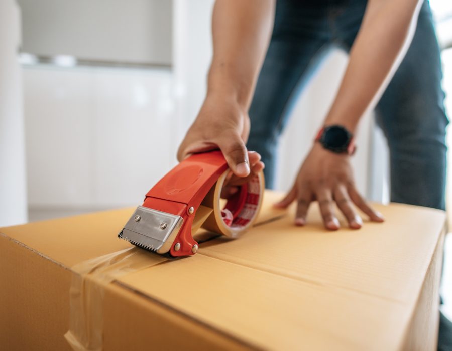 Close up hand of man use glue tape to close cardboard box, sealing big box for packing moving, new house concept, Selective focus	cardboard box,