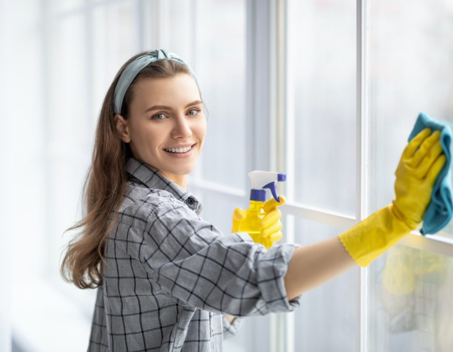 smiling-young-woman-with-detergent-and-rag-cleaning-window-glass-professional-sanitary-service.jpg